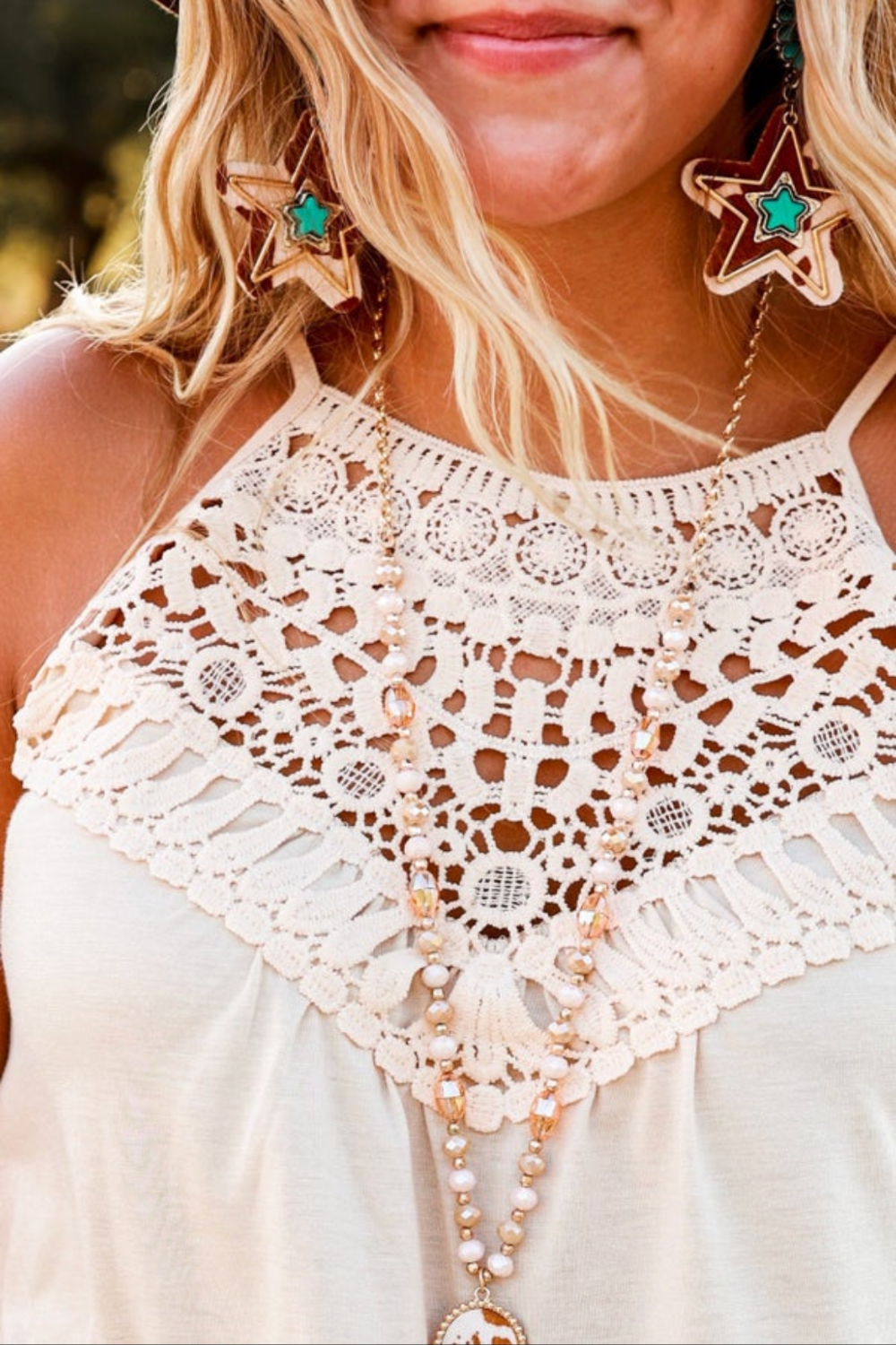 Upclose detail of the crochet yoke, or neckline of the Lexington and Gray Sunrise crochet tank . Styled with gold and turquoise western jewelry. 