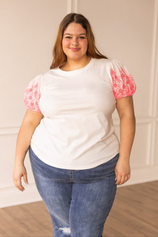 Plus size woman modeling size inclusive t-shirt with puff embroidered sleeves