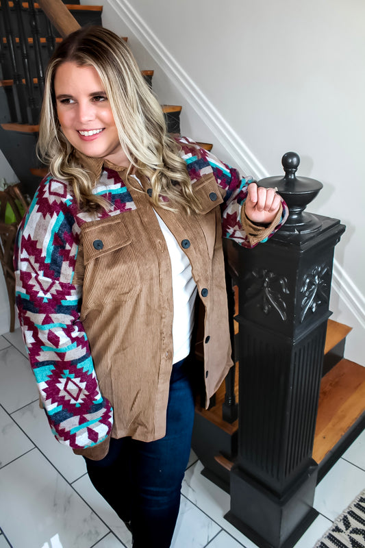 Woman posing on antique stairs modeling a Light Brown Corduroy and Aztec Printed Shacket available in women sizes small to 3x at the size inclusive boutique Lexington and Gray