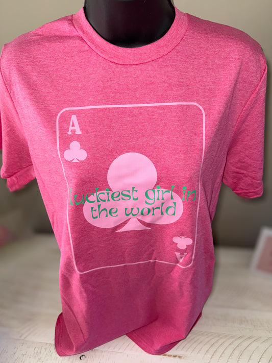 A pink Gildan Softstyle Unisex T-Shirt displayed on a mannequin, with text and a playing card symbol design.
