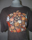A dark brown heather t-shirt displayed on a gray mannequin torso, featuring a large autumn-themed graphic print with pumpkins, gingham patterns, a ghost, and leaves.