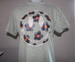 A light sage green short-sleeve t-shirt displayed on a mannequin torso, featuring a large circular graphic print on the back with stylized flowers in black, white, and orange.