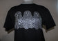 A black short-sleeve t-shirt displayed on a mannequin torso, featuring a large graphic print of three wavy ghost shapes filled with a white and gray spotted pattern resembling animal print or scales.