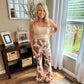 Jade by Jane High rise mocha cow print flare pants. Model wearing cow print flare pants and a one shoulder crop top for a trendy and casual outfit. Mocha Cow print pants available at Lexington and Gray sizes Small through 3x